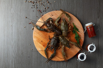 Four fresh crawfish on a wooden cutting board top view
