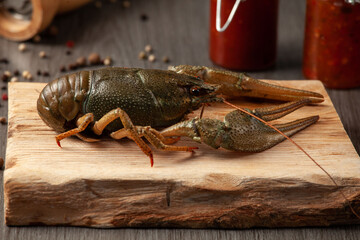 Large fresh crawfish on a wooden cutting board with pepper on the table