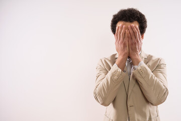 Image of desperate businessman covering his face.