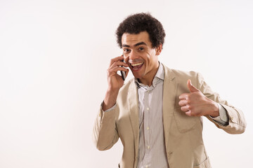 Image of happy businessman talking on the phone and showing thumb up.