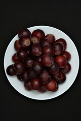 Red fresh grapes. Grapes on a plate. Large grapes.