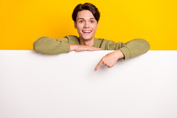 Photo of excited positive man wear trendy clothes arm direct empty space special offer proposition isolated on yellow color background