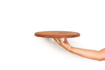 Mano de mujer sosteniendo un plato redondo de madera sobre un fondo blanco liso y aislado. Vista de frente y de cerca. Copy space