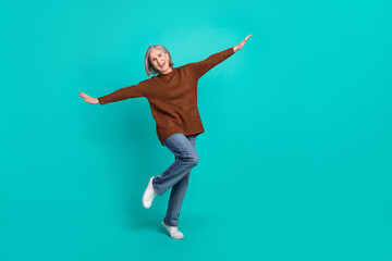 Fototapeta na wymiar Full body portrait of cheerful pretty aged lady have good mood arms wings empty space isolated on turquoise color background