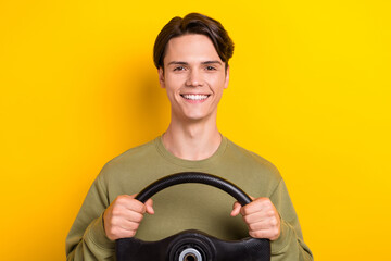 Photo of nice cheerful man beaming smile arms hold wheel isolated on yellow color background