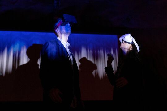 Multiracial female and male colleagues watching through futuristic glasses in workshop