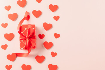 Top view flat lay of paper hearts and gift box on pastel pink background surprise your loved with space for text, birthday greeting, web design banner holiday, Happy Valentine Day Background
