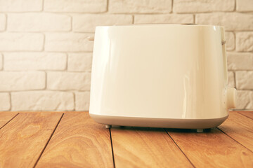 Modern white electric toaster for bread on the wooden kitchen table. Cooking and homeware technologies