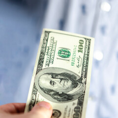 Bill of 100 dollars in the hands of a person