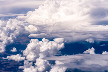 Aerial view of large puffy clouds outside of my airplane window