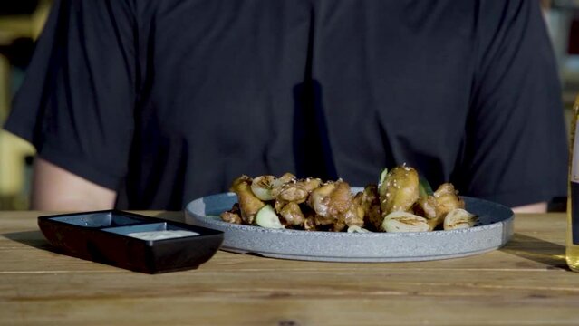 Man Eating Chicken Wings With Chipotle Dip