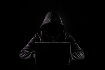 No face hacker with laptop on dark background.