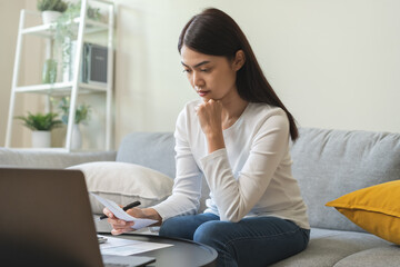 Deduction planning concept. Asian young woman hand holding bills for calculating balance prepare...