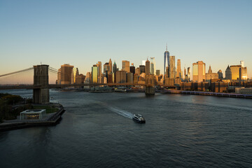 Fototapeta na wymiar Skyline im Abendlicht mit Boot und Fluss in New York und Brooklyn.