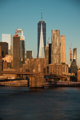 Obraz premium New York mit Brooklyn Bridge im goldenen Abendlicht und blauem Himmel.