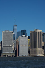 Obraz premium New York Skyline mit Wasser und blauem Himmel und Gebäuden von Fluss aus.