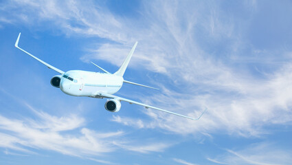 Fototapeta premium White passenger airplane flying in the sky amazing clouds in the background - Travel by air transport
