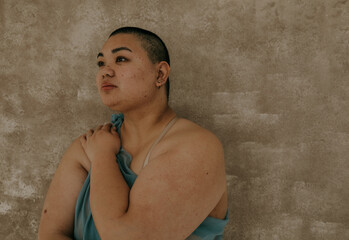 profile of a plus size filipino woman with a shaved head eyes looking away
