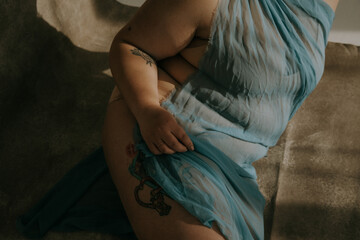 close-up of plus size filipino woman's body sitting on the ground hand on thigh