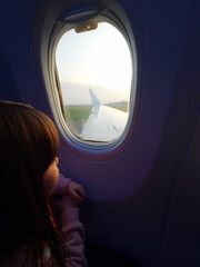 Fototapeta na wymiar Girl looking at airplane window