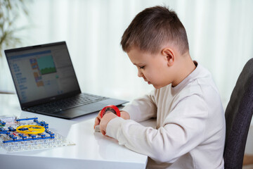 School boy remotely learn online at home in coding robot and electronic board in STEM, computer code in robotics for kids concept.