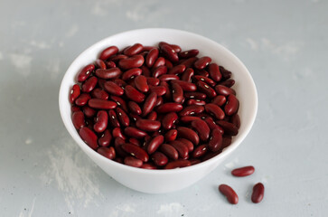 Red beans in a white bowl on a gray background. The concept of vegan food. Horizontal orientation.