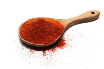 Red paprika, cayenne pepper powder in wooden spoon pile isolated on white, side view 