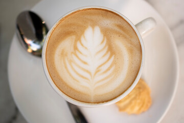 Taza de café con una flor dibujada en el centro