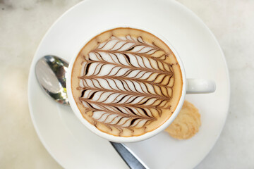 Taza de café con hojas dibujadas en el centro