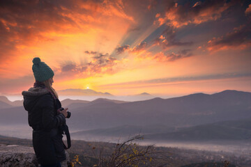 Beautiful young female photographer shooting with professional camera in Outdoor.  