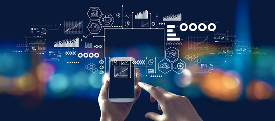 Industry 4.0 theme with person using a smartphone in a city at night