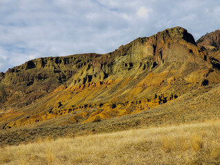 Golden hour lights up the bluff and cliffs at Cinnamon Ridge outside of Kamloops BC, near the...