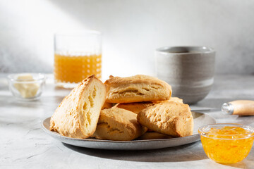 Traditional British scones served with orange jam on gray background.