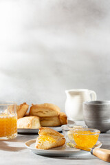 Traditional British scones served with orange jam on gray background. Copy space.