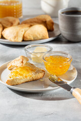 Traditional British scones served with orange jam on gray background.