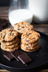 Chocolate cookies with pieces of chocolate on a wooden background