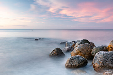 rosa Abenddämmerung am Meer mit Felsen