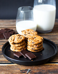 Chocolate cookies with pieces of chocolate on a wooden background