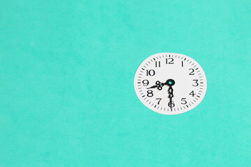 Clock face with arrows at 20:30 with space for text. Global ecology, International Day of Energy Saving or Earth Hour concept. On a turquoise background.