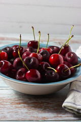 Fresh cherrys on plate on wooden background. Fresh ripe cherries. Sweet cherries.