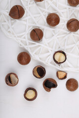Close-up of macadamia nuts on a white stone, slate or concrete background, the concept of superfoods and healthy nutrition, a picture from above or with a view from above in a vintage color tone
