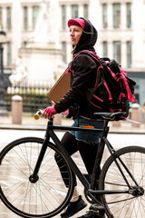 Bike courier taking a parcel and walking with bike.
