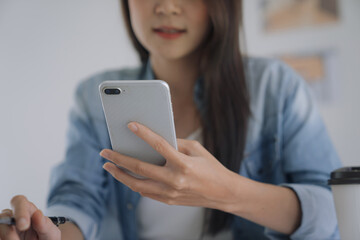 Working woman Asian Architects designer using smartphone with laptop