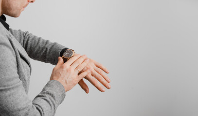 Man checking time on his wrist watch, grey background - 569310775