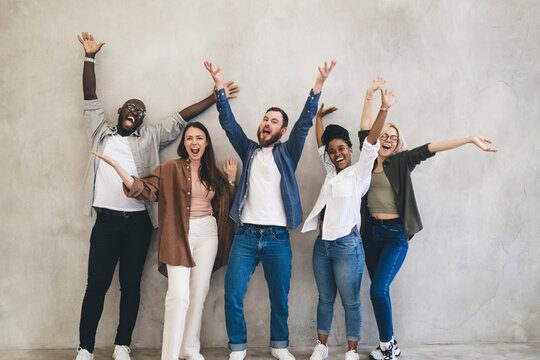 Happy diverse friends having fun with raised arms