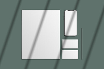 Notebook, pencils, stationery and templates of different shapes on a green background.