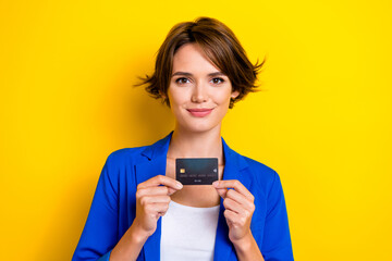 Photo of confident attractive business company owner woman hold her premium bank card no percent payment isolated on yellow color background