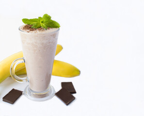Banana chocolate cocktail in the drinking glass on the white background. Copy space. Close-up.