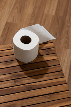 White toilet paper on a wooden table. Top view.