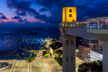 Facade of the famous Lacerda elevator illuminated at night with city and boats in background in...